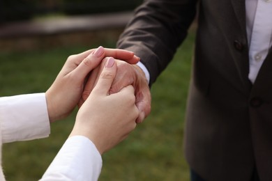 Trust and deal. Partners joining hands outdoors, closeup