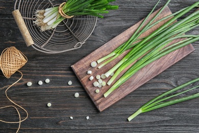 Photo of Beautiful composition with fresh green onion on wooden table, top view