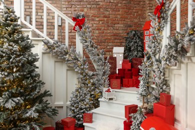 Photo of Christmas tree, gift boxes and festive decor indoors. Interior design