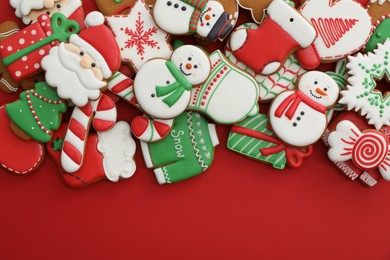 Photo of Different Christmas gingerbread cookies on red background, flat lay