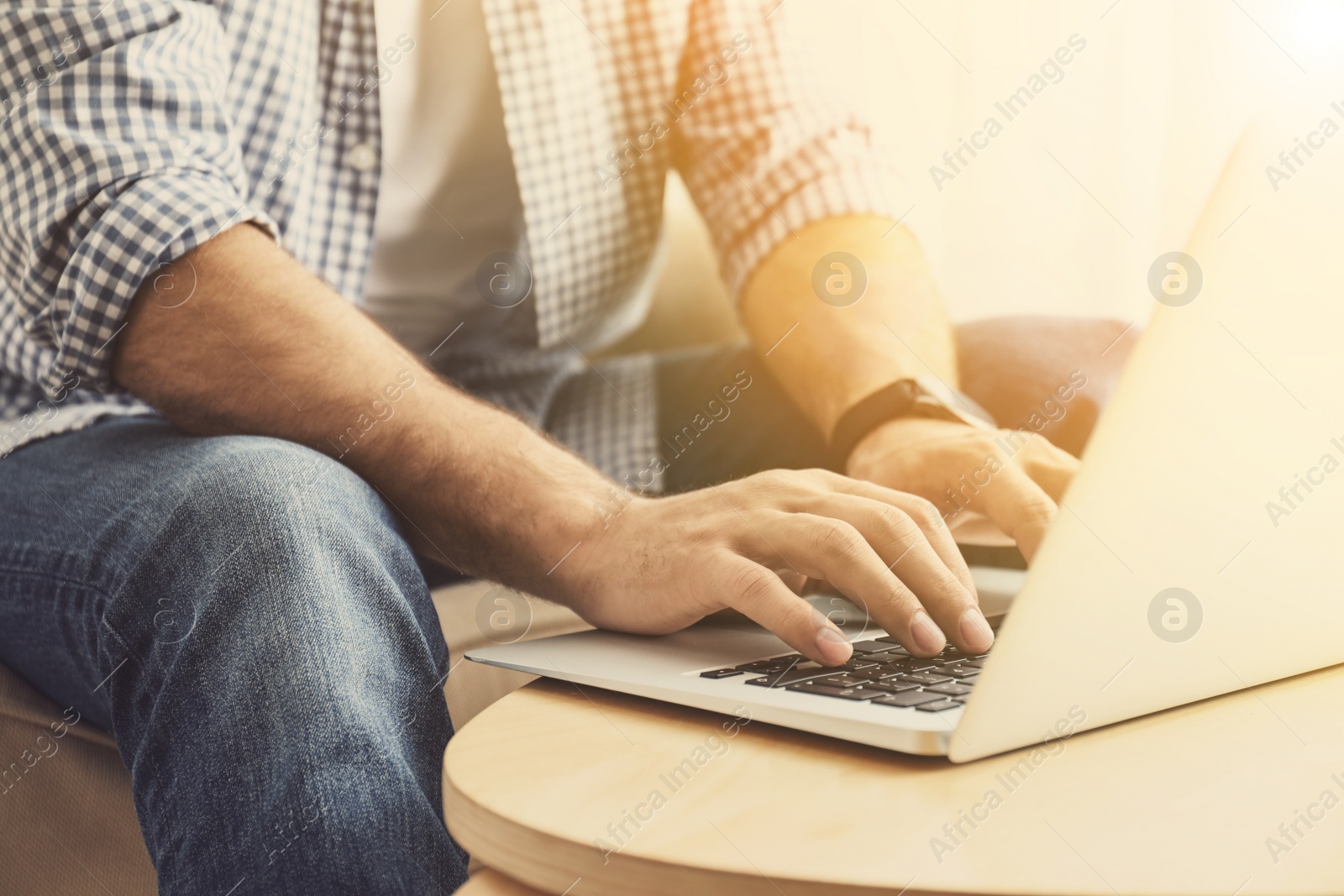 Image of Man working with laptop at wooden table indoors, closeup