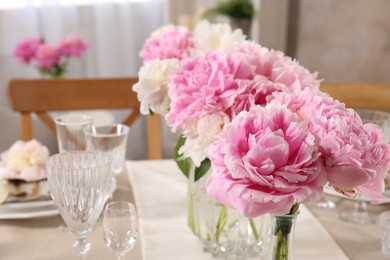 Stylish table setting with beautiful peonies indoors. Space for text