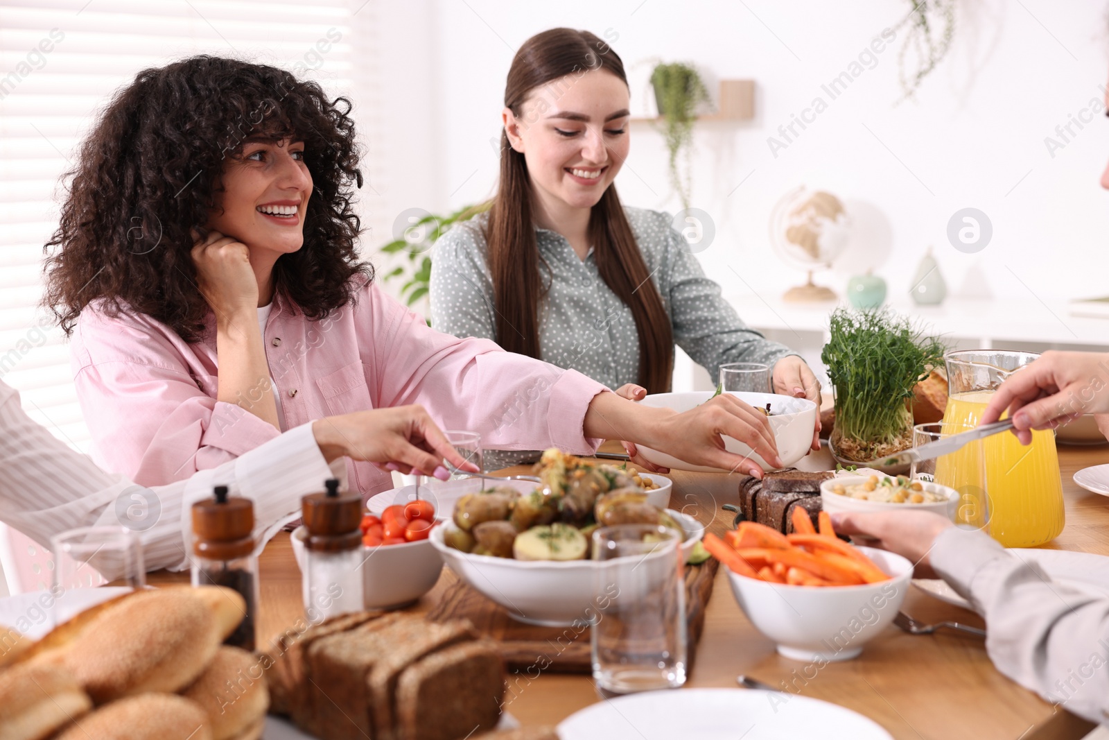 Photo of Friends eating vegetarian food at table indoors