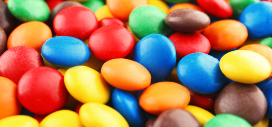 Many colorful candies as background, top view. Banner design 