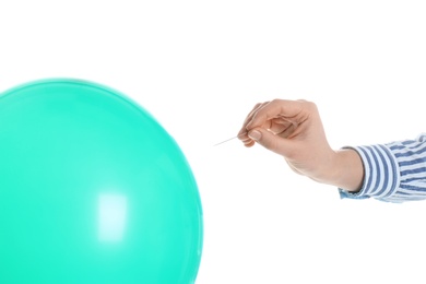 Woman piercing green balloon on white background, closeup