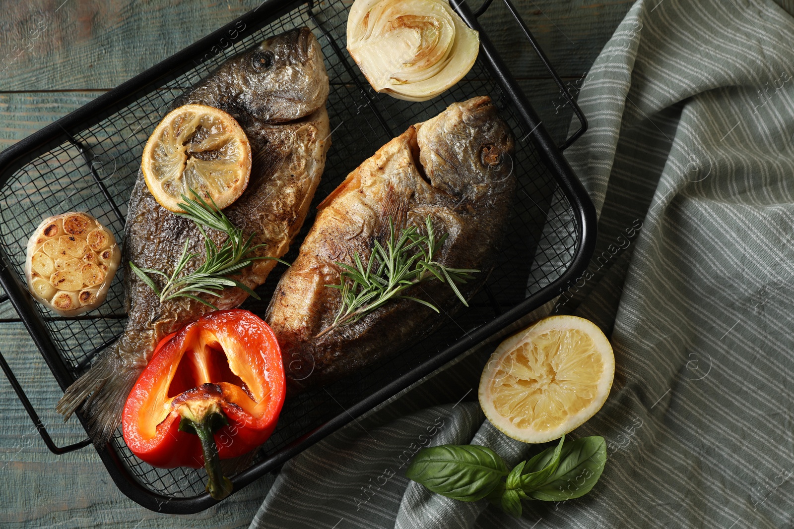 Photo of Delicious dorado fish with vegetables served on wooden table, flat lay