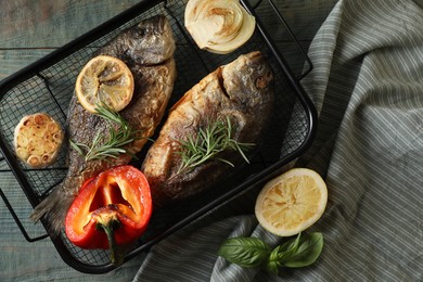 Photo of Delicious dorado fish with vegetables served on wooden table, flat lay