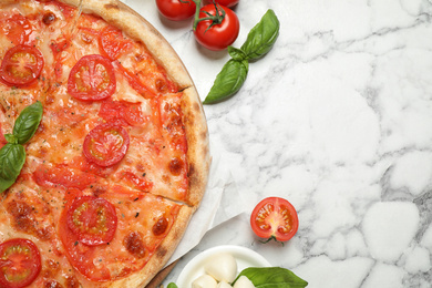 Delicious pizza Margherita and ingredients on white marble table, flat lay. Space for text