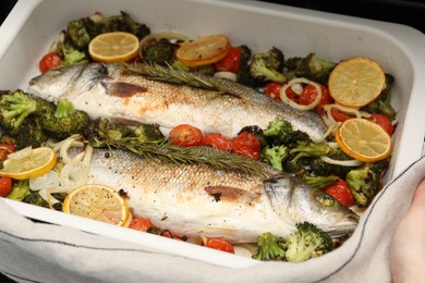 Photo of Delicious fish with vegetables and lemon in baking dish