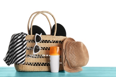 Set of beach accessories on blue wooden table, white background