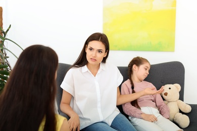 Young woman and her daughter having appointment with child psychologist in office