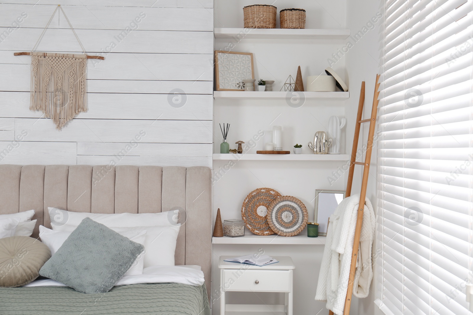 Photo of Wall shelves with beautiful decor elements in stylish bedroom interior