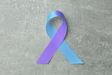 Image of World Arthritis Day. Blue and purple awareness ribbon on light grey background, top view