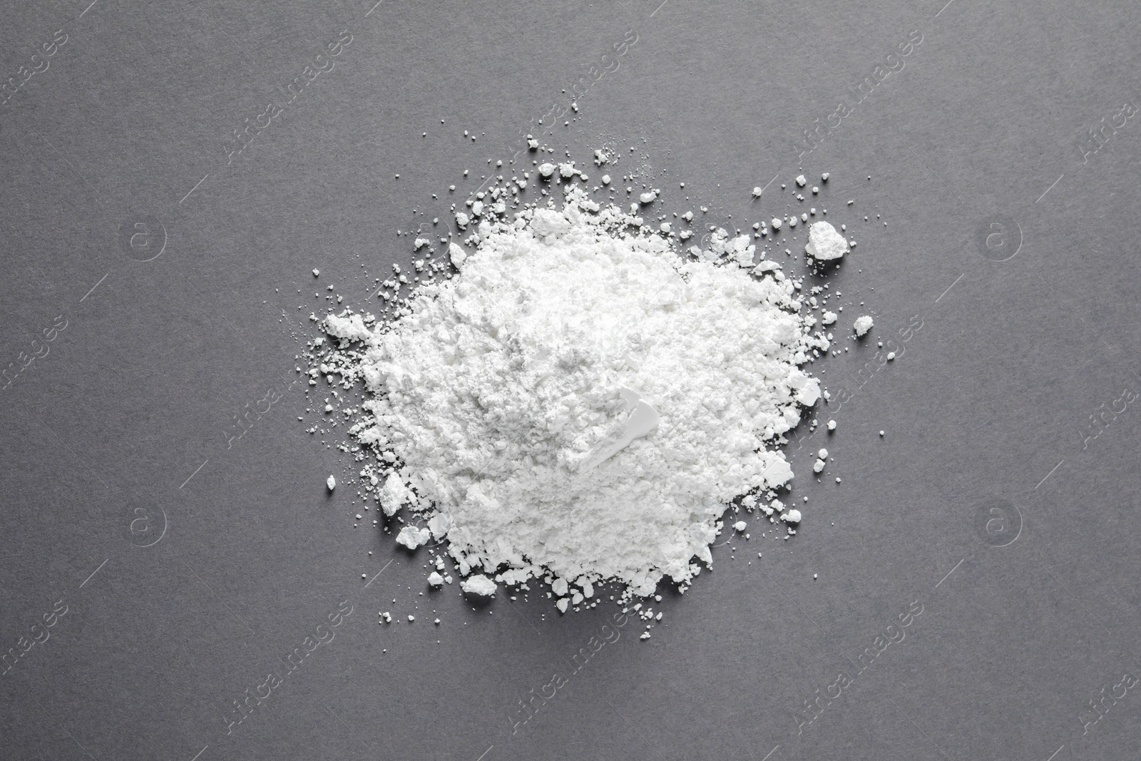 Photo of Heap of calcium carbonate powder on grey table, top view