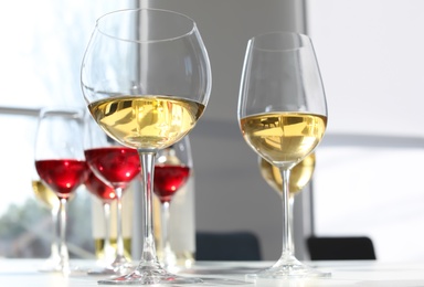 Photo of Glasses with delicious wine on table indoors