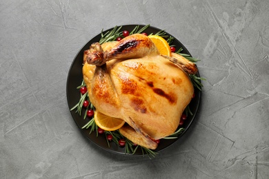 Delicious cooked turkey served with rosemary, oranges and cranberries on grey table, top view. Thanksgiving Day celebration