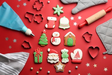 Photo of Flat lay composition with delicious gingerbread cookies and kitchen items on red background