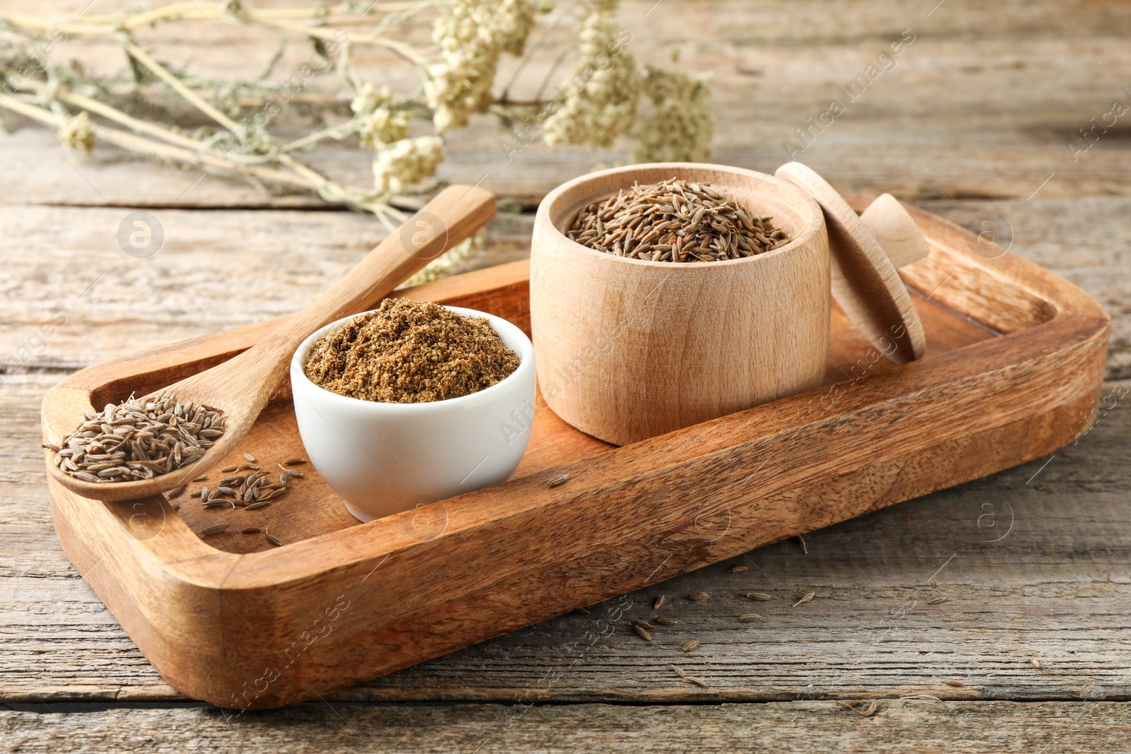 Photo of Caraway (Persian cumin) powder and dry seeds on wooden table, closeup