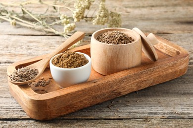 Photo of Caraway (Persian cumin) powder and dry seeds on wooden table, closeup