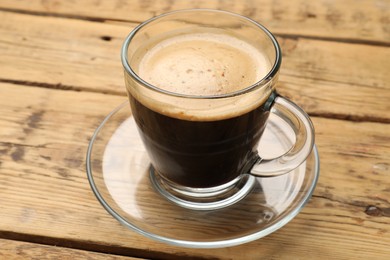 Cup of aromatic coffee on wooden table, closeup