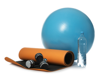 Photo of Fitness ball, yoga mat, bottle of water and dumbbells isolated on white