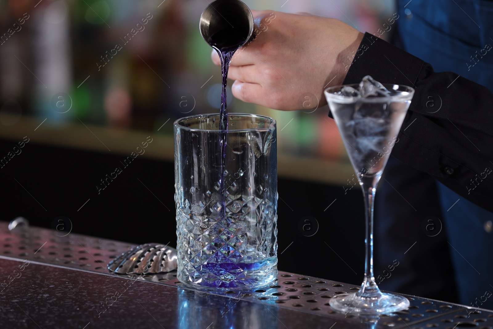 Photo of Bartender making fresh alcoholic cocktail at bar counter, closeup