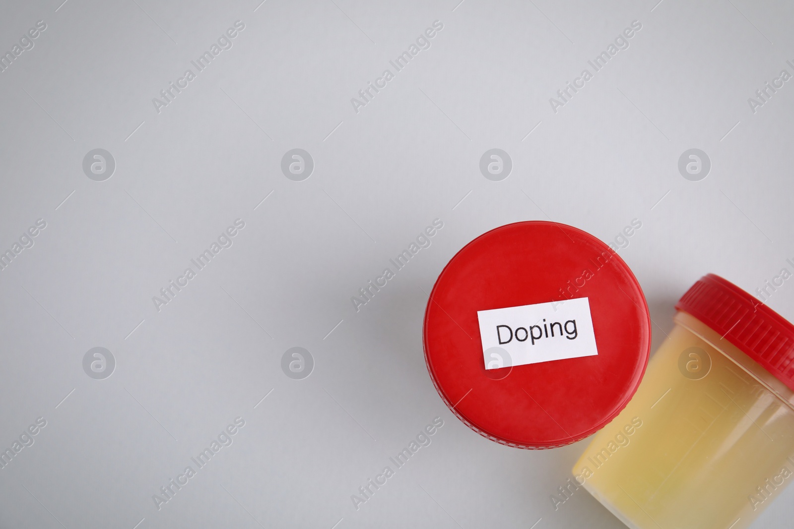 Photo of Jars with urine samples on light grey background, flat lay and space for text. Doping control