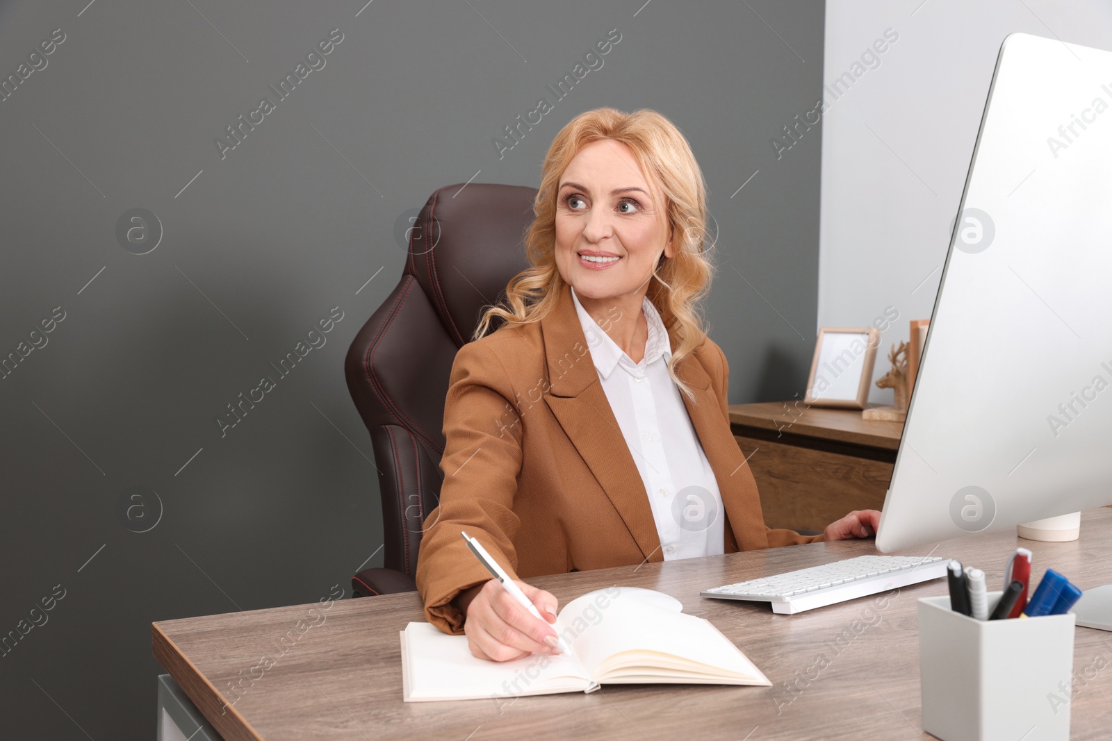 Photo of Lady boss working near computer at desk in office. Successful businesswoman