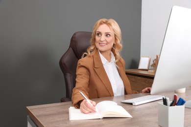 Photo of Lady boss working near computer at desk in office. Successful businesswoman