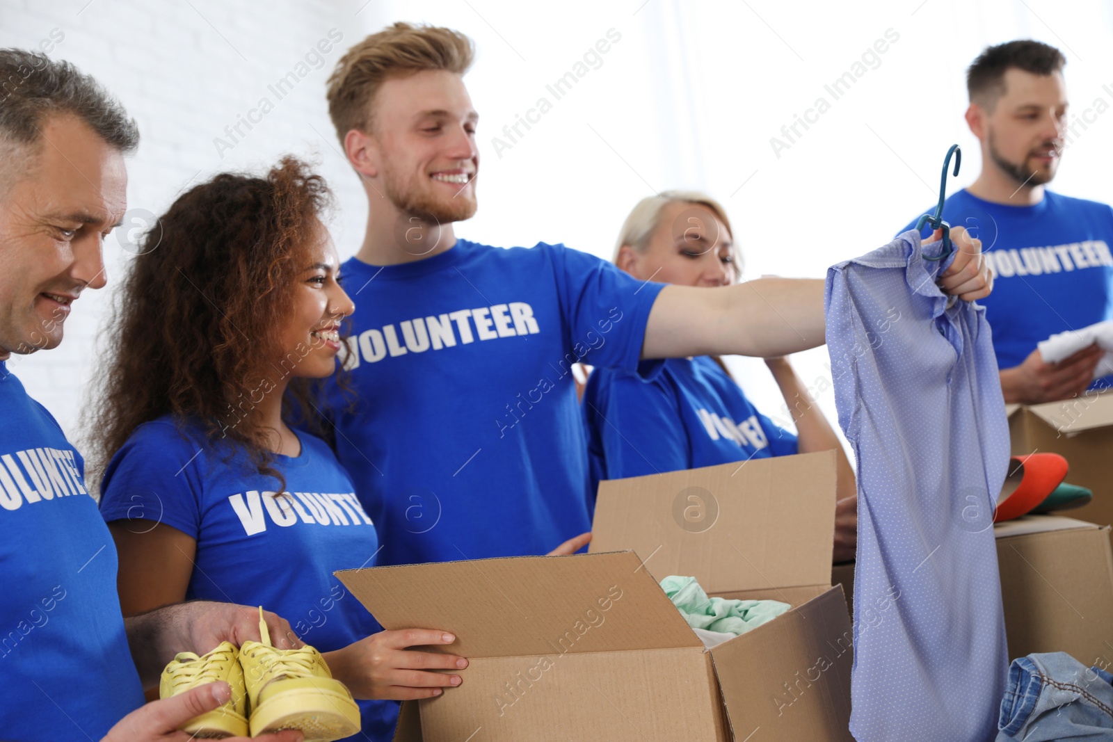 Photo of Team of volunteers collecting donations in boxes indoors