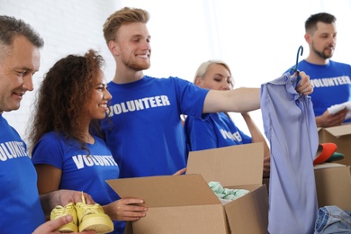 Team of volunteers collecting donations in boxes indoors