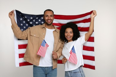 4th of July - Independence Day of USA. Happy couple with American flags on white background