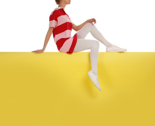 Photo of Woman wearing white tights and stylish shoes sitting on color background, closeup