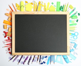 Photo of Composition with different school stationery and small chalkboard on white background, top view