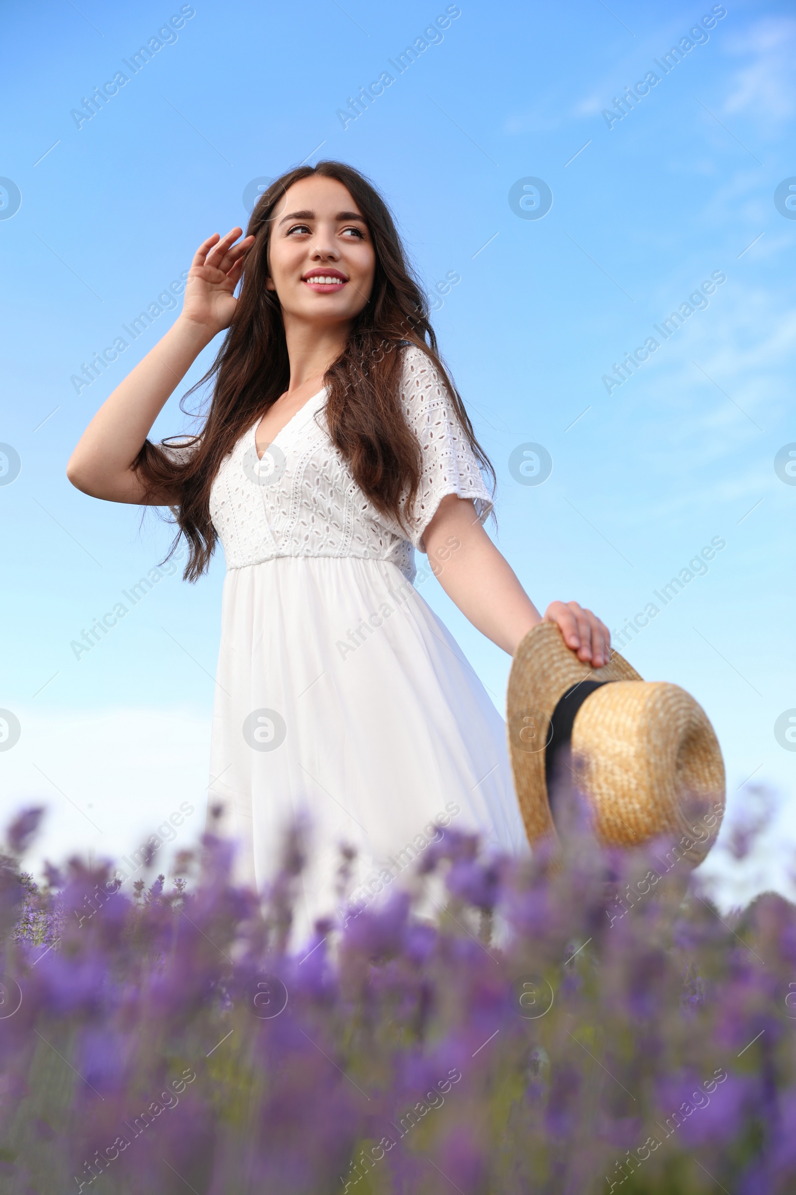 Photo of Young woman with straw hat in lavender field