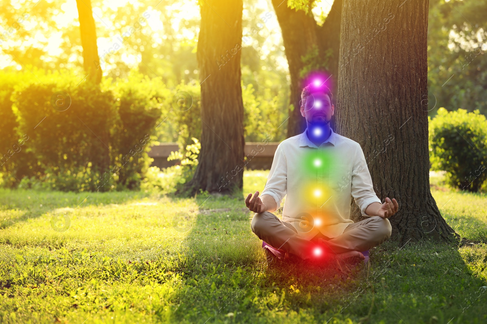 Image of Man meditating in park on sunny summer day. Scheme of seven chakras, illustration