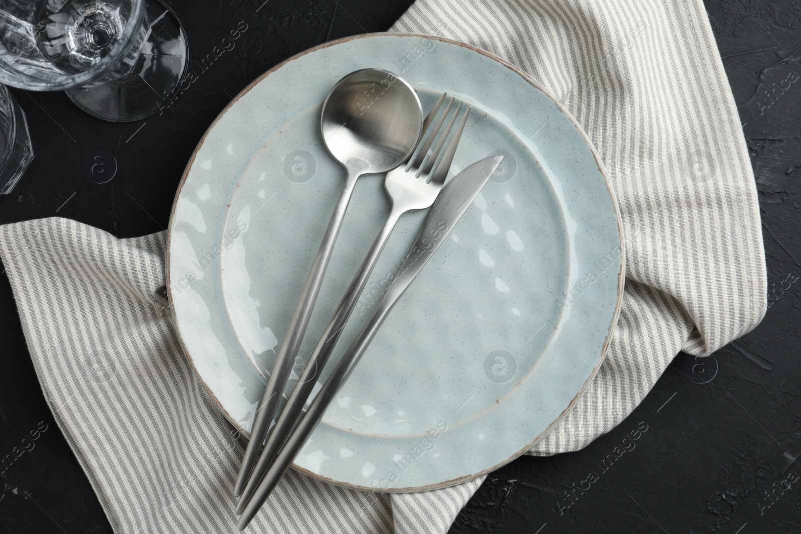 Photo of Stylish setting with cutlery, napkin and plate on dark table, flat lay