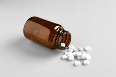 Photo of Medical bottle and pills on white background