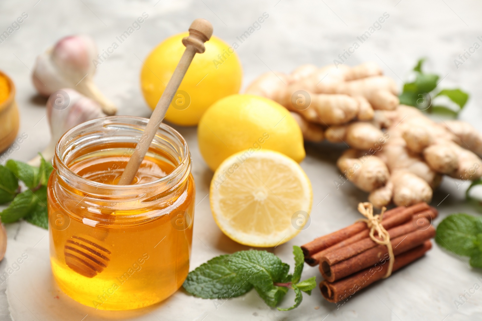 Photo of Honey and other fresh products on grey table. Natural antibiotics