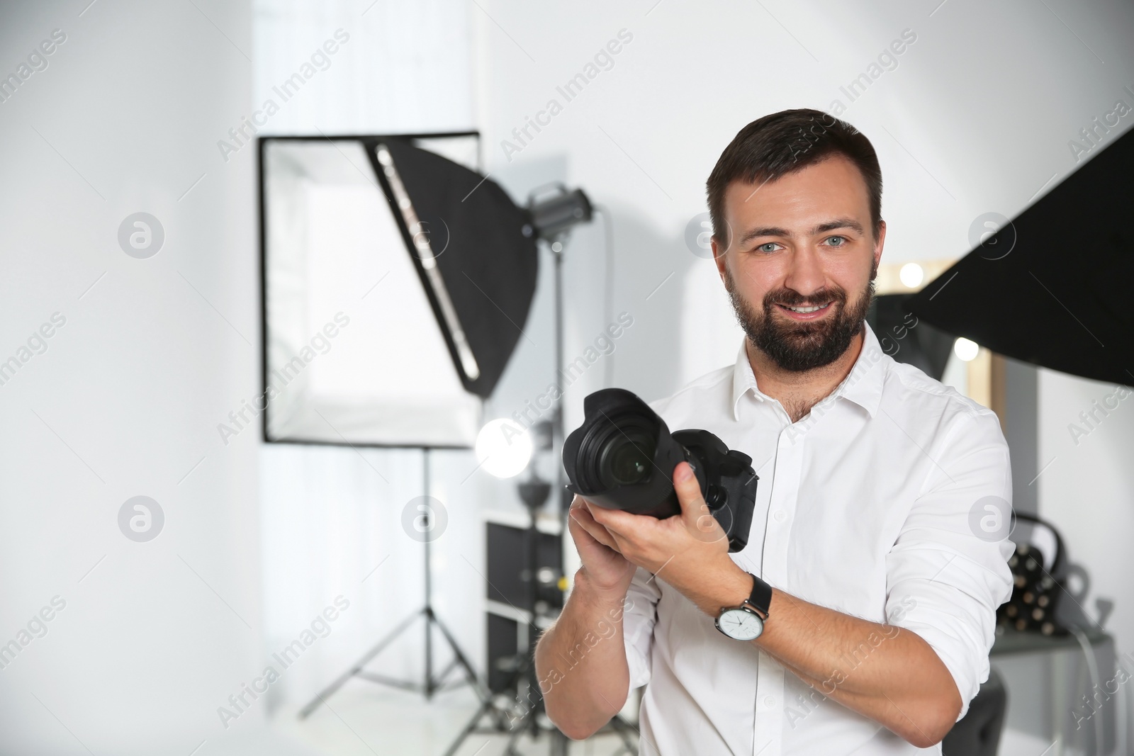 Photo of Professional photographer with camera in photo studio