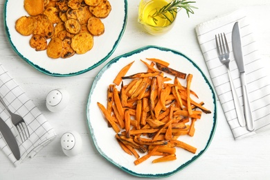 Plates with baked sweet potato slices served on table, top view