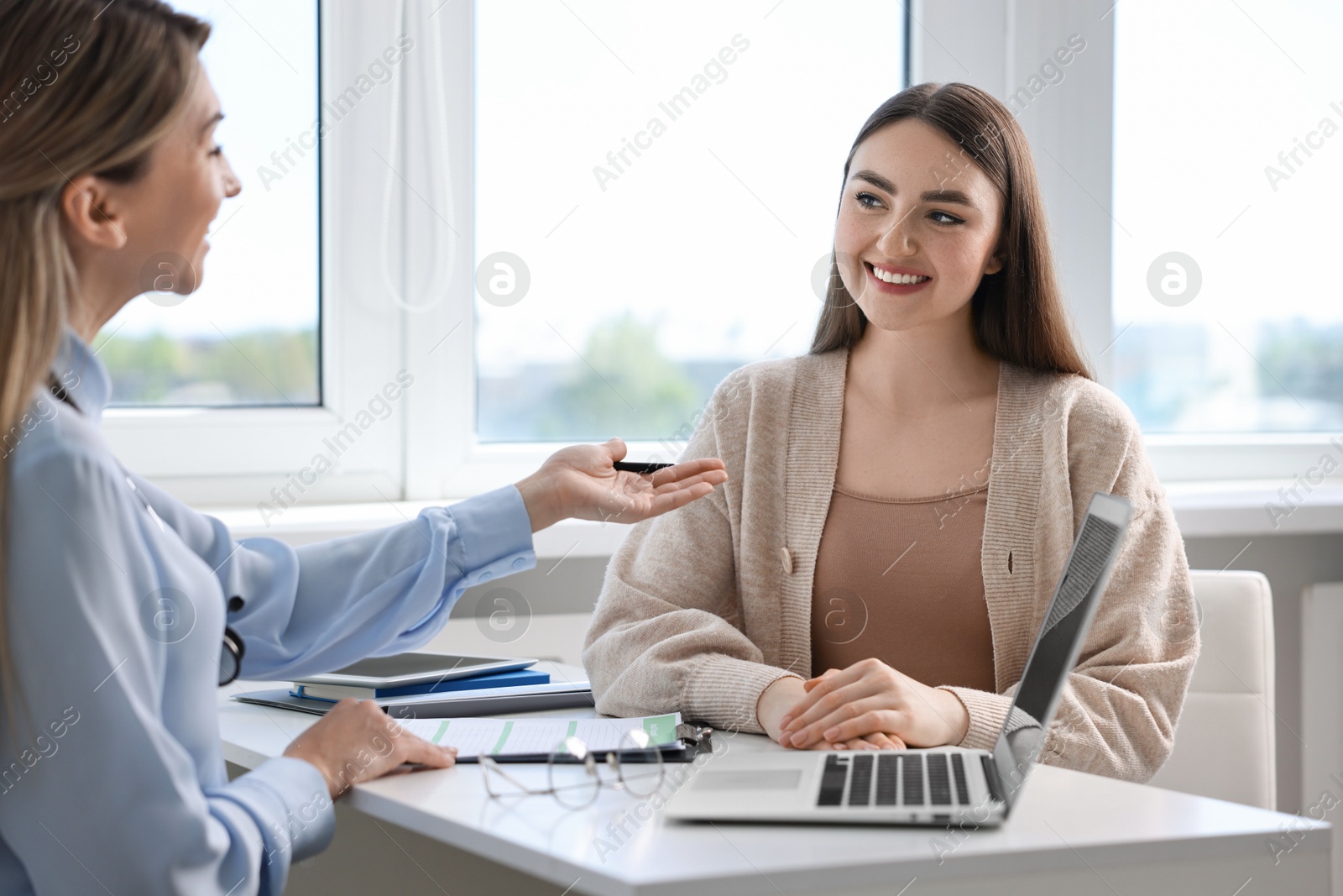 Photo of Professional doctor working with patient at white table in hospital