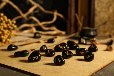 Photo of Wooden board with many black rune stones on table