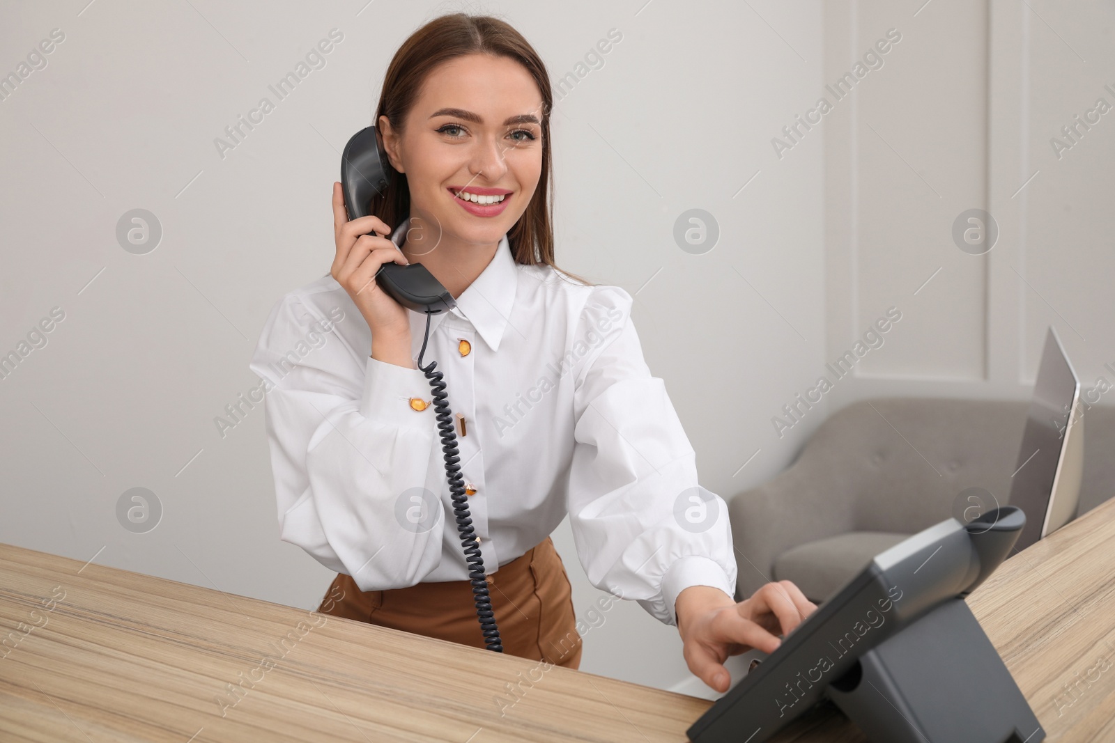 Photo of Female receptionist talking on phone at workplace