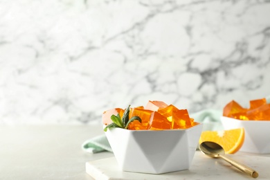 Photo of Composition with orange jelly in bowl on  table. Space for text