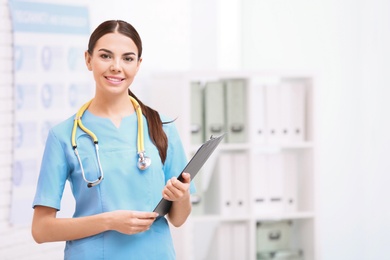 Photo of Portrait of medical assistant with stethoscope and clipboard in hospital. Space for text