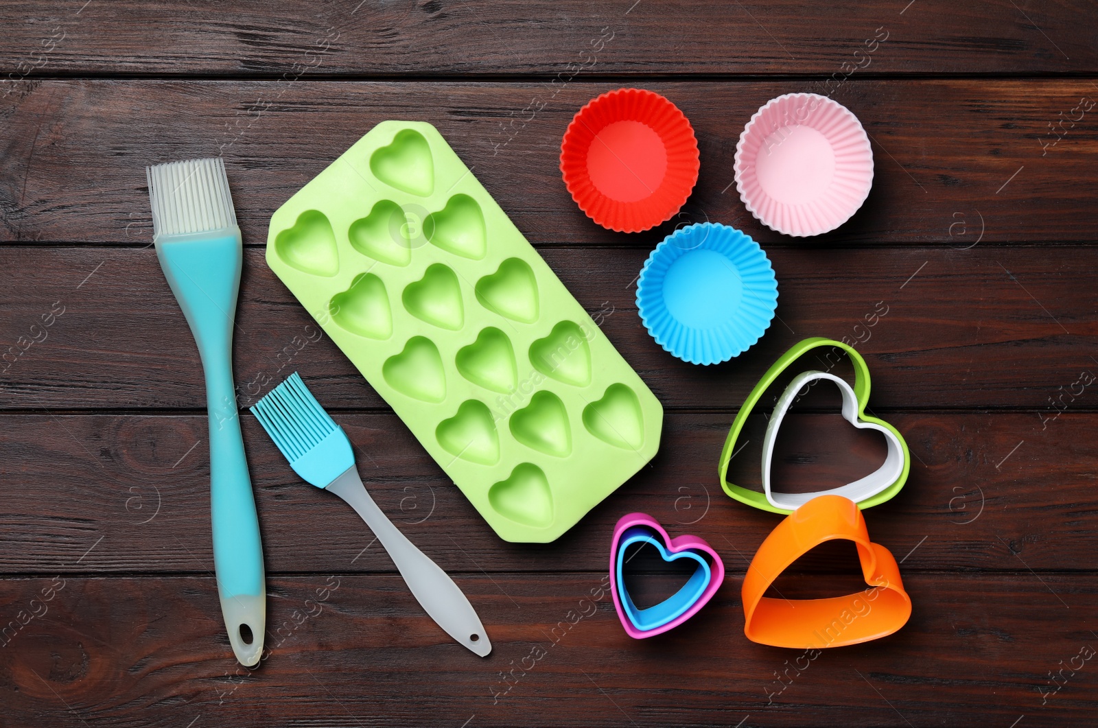 Photo of Set of modern baking utensils on brown wooden table, flat lay