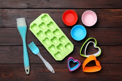 Photo of Set of modern baking utensils on brown wooden table, flat lay