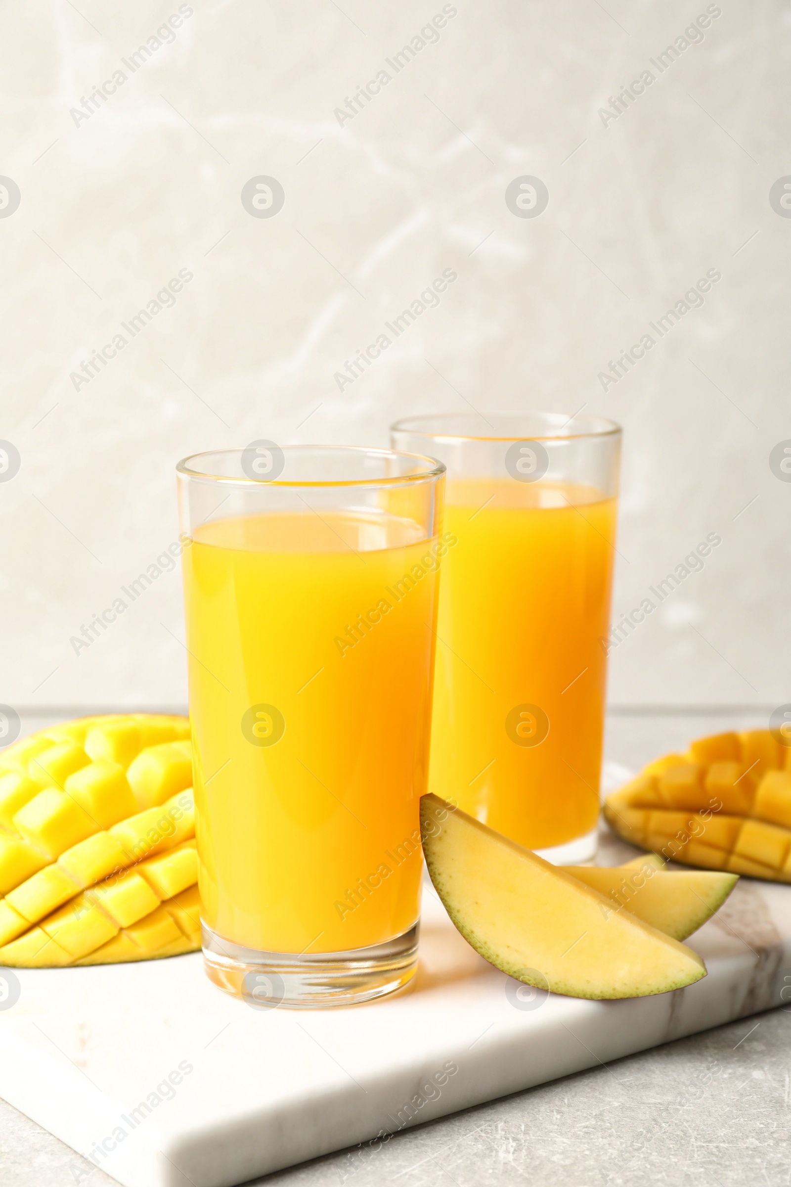 Photo of Fresh mango drink and cut fruits on table. Space for text