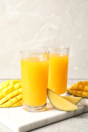 Fresh mango drink and cut fruits on table. Space for text